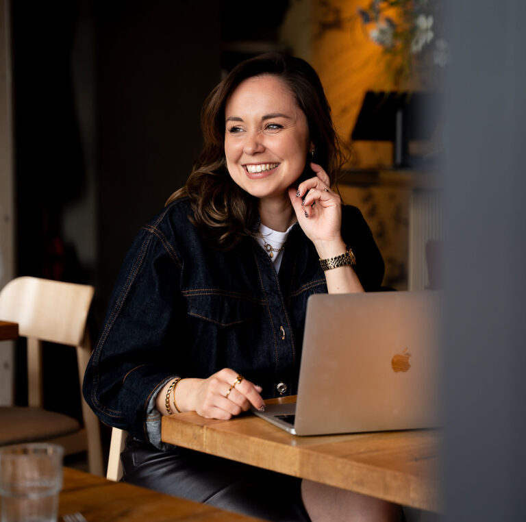 woman on a table with laptop, looking at the left side